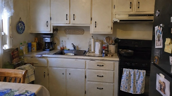 Old kitchen cabinets showing scratches, discoloration, grease buildup, and worn hardware before repainting.